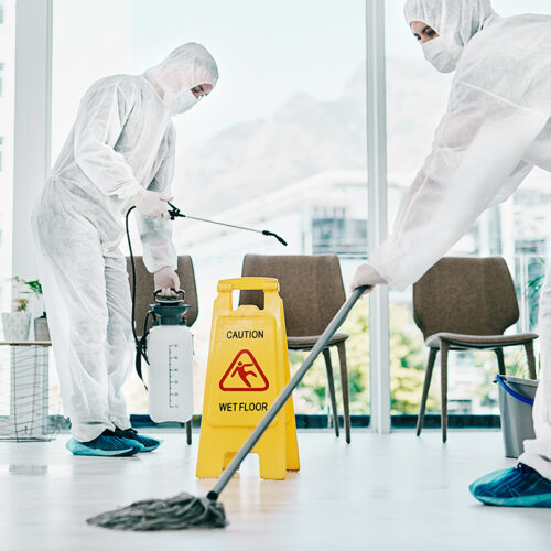 Shot of healthcare workers wearing hazmat suits and sanitising a room during an outbreak